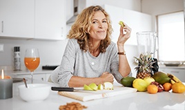 Woman eating healthy snack in kitchen