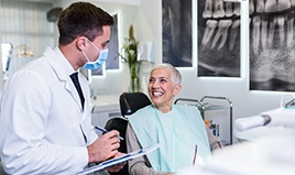 Woman smiling while talking to dentist during checkup