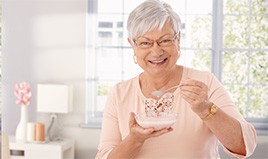 Woman eating yogurt with dental implants 